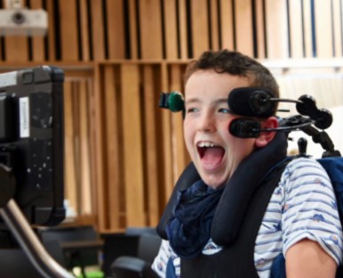 Young beneficiary laughing during a Sunbeams music session