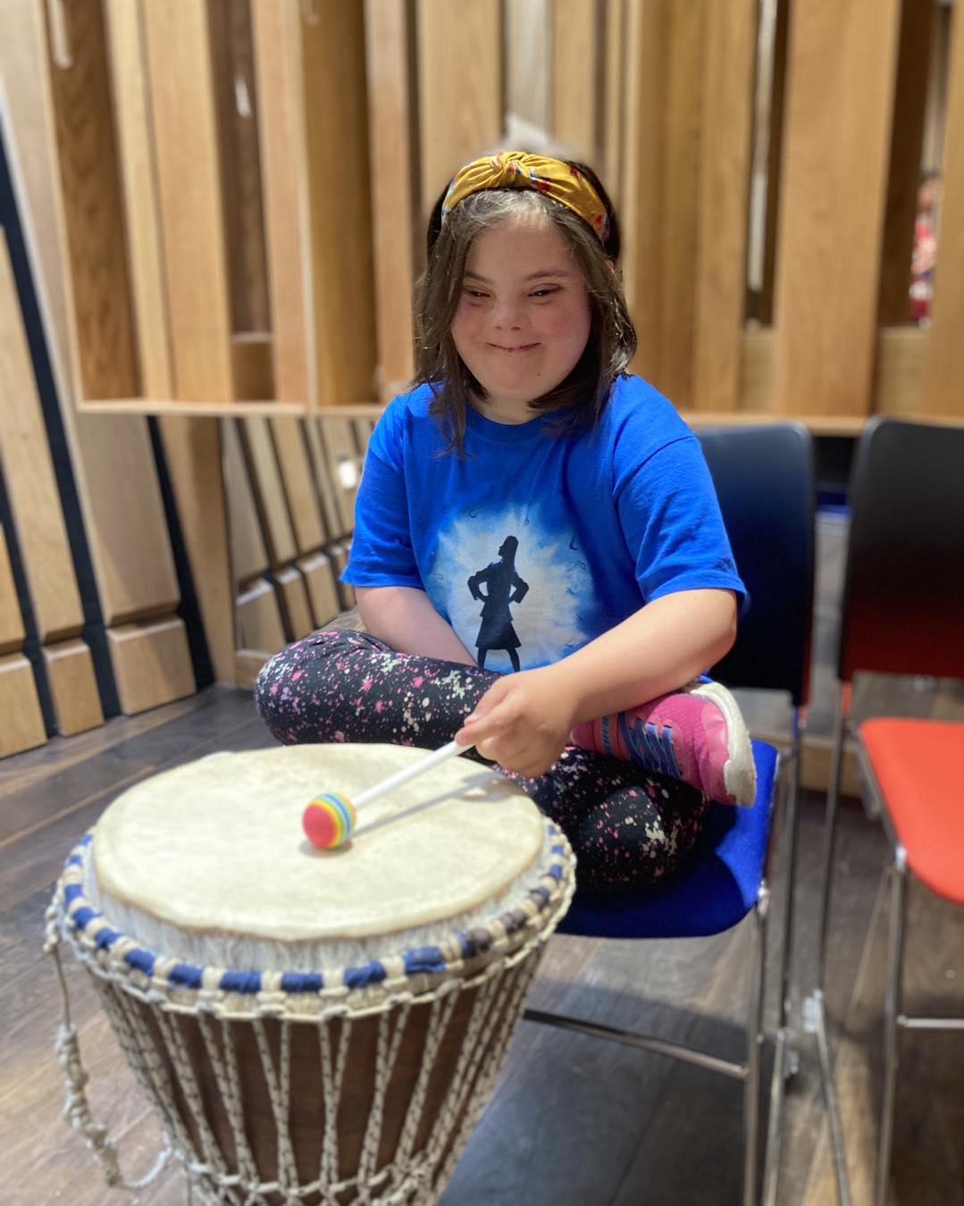Young girl playing a djembe drum at Sunbeams